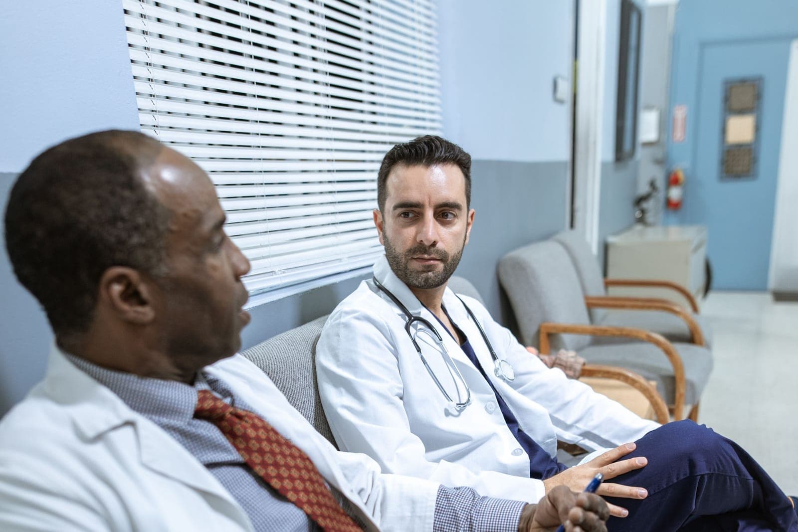 Dois médicos conversando em ambiente hospitalar