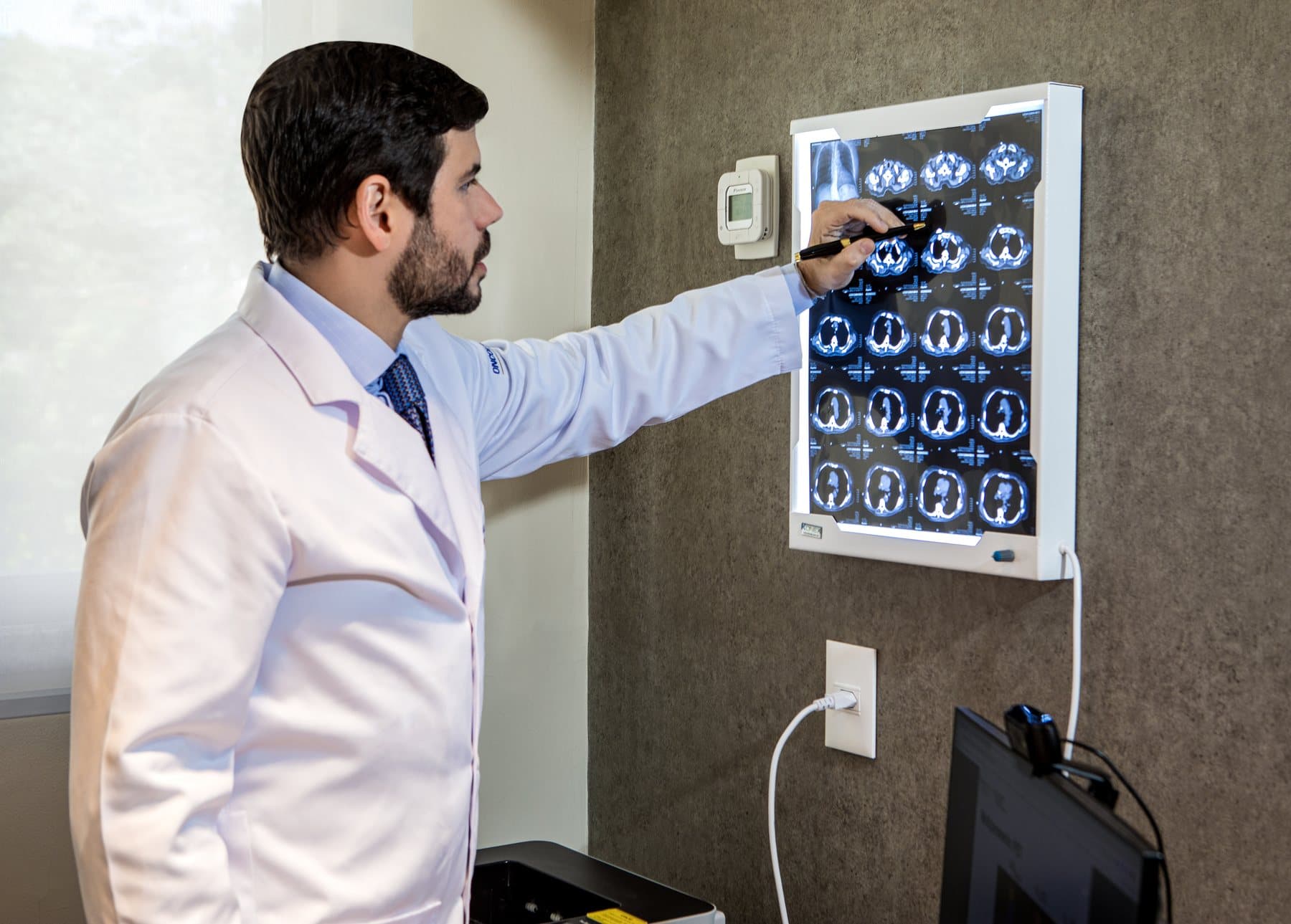 Dr. Vinicius Carrera analisando tomografia de tórax no consultório