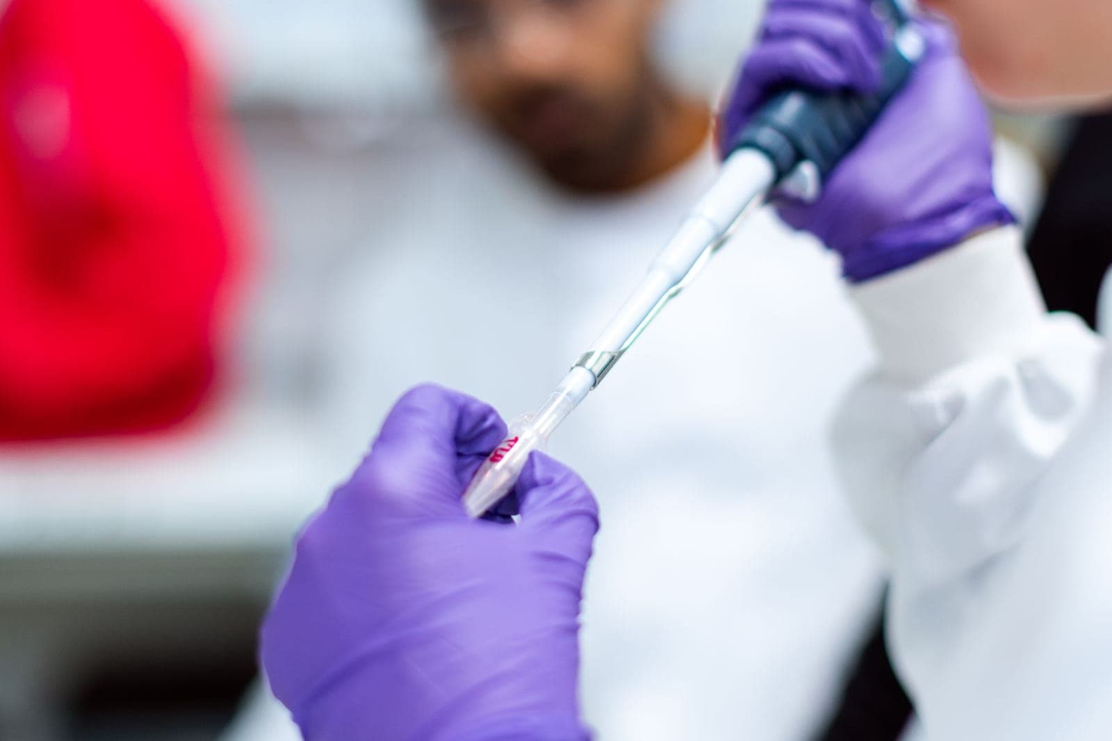 Pesquisador pipetando amostra em microtubo em laboratório de análise molecular